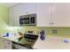 Modern kitchen with white cabinets, stainless steel appliances, and light flooring at 1410 21St W St, Bradenton, FL 34205