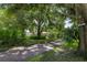 Long driveway leading to a single Gathering home with mature trees at 1525 17Th W St, Palmetto, FL 34221