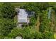 Aerial view of house, pool, and lush landscaping with solar panels at 1525 17Th W St, Palmetto, FL 34221