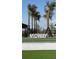 A stylish neighborhood entrance sign with palm trees and a landscaped setting welcomes residents and guests at 1217 Blue Shell Loop, Sarasota, FL 34240