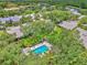 Community pool and surrounding homes and landscape visible in this aerial view at 4521 Kingsmere # 6, Sarasota, FL 34235