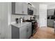 Modern kitchen with gray cabinets, stainless steel appliances and hardwood floors at 12925 Oak Hill Way, Parrish, FL 34219