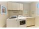 Laundry room with washer, dryer and cabinets at 2942 Trustee Ave, Sarasota, FL 34243