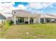 Large backyard featuring a covered patio and grassy area at 2803 Butterfly Jasmine Trl, Sarasota, FL 34240