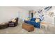 Cozy bonus room featuring a blue sofa, comfortable armchair, and artistic wall mural at 2803 Butterfly Jasmine Trl, Sarasota, FL 34240