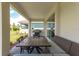 Covered patio with outdoor dining set and built-in grill at 2803 Butterfly Jasmine Trl, Sarasota, FL 34240