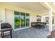 Covered patio with paver stone floor, outdoor seating, and grill at 2803 Butterfly Jasmine Trl, Sarasota, FL 34240