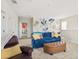 Bright bonus room with a blue sofa, comfortable armchair, and artistic wall mural at 2803 Butterfly Jasmine Trl, Sarasota, FL 34240