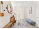 Light and airy entryway with a bench, mirror, and rug at 2803 Butterfly Jasmine Trl, Sarasota, FL 34240