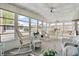 Bright sunroom with wicker furniture and large windows at 3410 Spanish Oak Ter, Sarasota, FL 34237