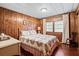 Cozy bedroom with wood paneled walls and a comfortable bed at 3410 Spanish Oak Ter, Sarasota, FL 34237