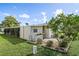 Tan mobile home exterior with well-manicured lawn and landscaping at 3410 Spanish Oak Ter, Sarasota, FL 34237