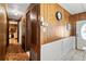 Long hallway with wood paneling and access to bedrooms at 3410 Spanish Oak Ter, Sarasota, FL 34237