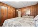 Bright bedroom with a double bed and wood-paneled walls at 3410 Spanish Oak Ter, Sarasota, FL 34237
