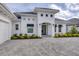 White stucco home with a paver driveway, landscaping and a modern entryway at 1217 Blue Shell Loop, Sarasota, FL 34240