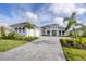Two-story home with white exterior, tile roof, and a paver driveway at 1217 Blue Shell Loop, Sarasota, FL 34240