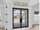 Modern black metal-framed glass double front door at 1217 Blue Shell Loop, Sarasota, FL 34240