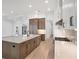 Open kitchen with island, stainless steel appliances, and white and wood cabinets at 1217 Blue Shell Loop, Sarasota, FL 34240