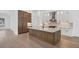 Modern kitchen with island, stainless steel appliances, and white shaker cabinets at 1217 Blue Shell Loop, Sarasota, FL 34240