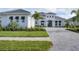 Luxury home exterior with gray roof, white walls, and landscaping at 1217 Blue Shell Loop, Sarasota, FL 34240