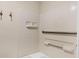 Shower with white tiled walls, grab bars, and built-in shelving, designed for accessibility and convenience at 6384 Draw Ln # 38, Sarasota, FL 34238