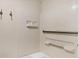 Clean bathroom featuring tile walls, grab bars, and built-in shelving for convenience at 6384 Draw Ln # 38, Sarasota, FL 34238