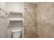 Shower with stone-style tiling, modern fixtures, built in shelving, and a low-flow toilet at 6384 Draw Ln # 38, Sarasota, FL 34238