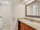 Bathroom with granite countertop vanity, modern sink, framed mirror, and tile flooring leading into the toilet area at 6384 Draw Ln # 38, Sarasota, FL 34238