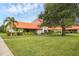 Beautiful single-story home showcasing a well-maintained lawn, mature trees, and a charming orange tiled roof at 6384 Draw Ln # 38, Sarasota, FL 34238