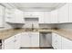 Well-lit kitchen featuring white cabinets, stainless steel appliances, and granite countertops at 6384 Draw Ln # 38, Sarasota, FL 34238