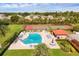 Community pool with lounge chairs and umbrellas, situated next to tennis courts and lush greenery at 6384 Draw Ln # 38, Sarasota, FL 34238
