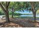 Peaceful lakeside view with shaded benches under large trees at 12105 Goldenrod Ave, Bradenton, FL 34212