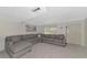 Spacious living room with large sectional sofa and coastal artwork at 3225 Ramblewood Dr, Sarasota, FL 34237