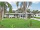 House with palm trees, green lawn, and a screened porch at 1215 Cypress Ave, Venice, FL 34285