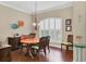 Dining room with hardwood floors, oval table, and white plantation shutters at 3165 Stokie Ave, North Port, FL 34286