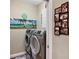 Bright laundry room with modern washer and dryer, tropical-themed decor at 3165 Stokie Ave, North Port, FL 34286