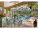Relaxing screened-in pool area with patio furniture and lush landscaping at 3165 Stokie Ave, North Port, FL 34286