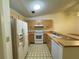 Bright kitchen features wood cabinets, white appliances, and patterned flooring at 3925 Oakhurst Blvd # 3010, Sarasota, FL 34233
