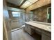 Bathroom with double vanity, shower, and patterned wallpaper at 3925 Oakhurst Blvd # 3010, Sarasota, FL 34233