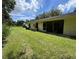 Home's backyard with grassy lawn and screened patio at 3925 Oakhurst Blvd # 3010, Sarasota, FL 34233
