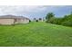 Large grassy backyard with a view of neighboring houses at 13592 Clara Ln, Port Charlotte, FL 33981