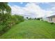 Large backyard with green grass and partial home view at 13592 Clara Ln, Port Charlotte, FL 33981