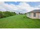 Large backyard with green grass and partial home view at 13592 Clara Ln, Port Charlotte, FL 33981