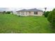 Large backyard with green grass and home view at 13592 Clara Ln, Port Charlotte, FL 33981