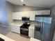 Modern kitchen with stainless steel appliances and white cabinets at 13592 Clara Ln, Port Charlotte, FL 33981