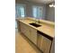 Kitchen island with sink, dishwasher, and white cabinets at 13592 Clara Ln, Port Charlotte, FL 33981