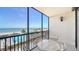 A sunny balcony features seating and stunning views of the beach, ocean, and community pool at 1945 Gulf Of Mexico Dr # M2-310, Longboat Key, FL 34228
