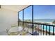 A sunny balcony features seating and stunning views of the beach, ocean, and community pool at 1945 Gulf Of Mexico Dr # M2-310, Longboat Key, FL 34228
