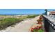 Beautiful beachside path with vibrant red flowers and views of the ocean at 1945 Gulf Of Mexico Dr # M2-310, Longboat Key, FL 34228