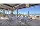 A covered outdoor patio with multiple tables and chairs and ocean view at 1945 Gulf Of Mexico Dr # M2-310, Longboat Key, FL 34228